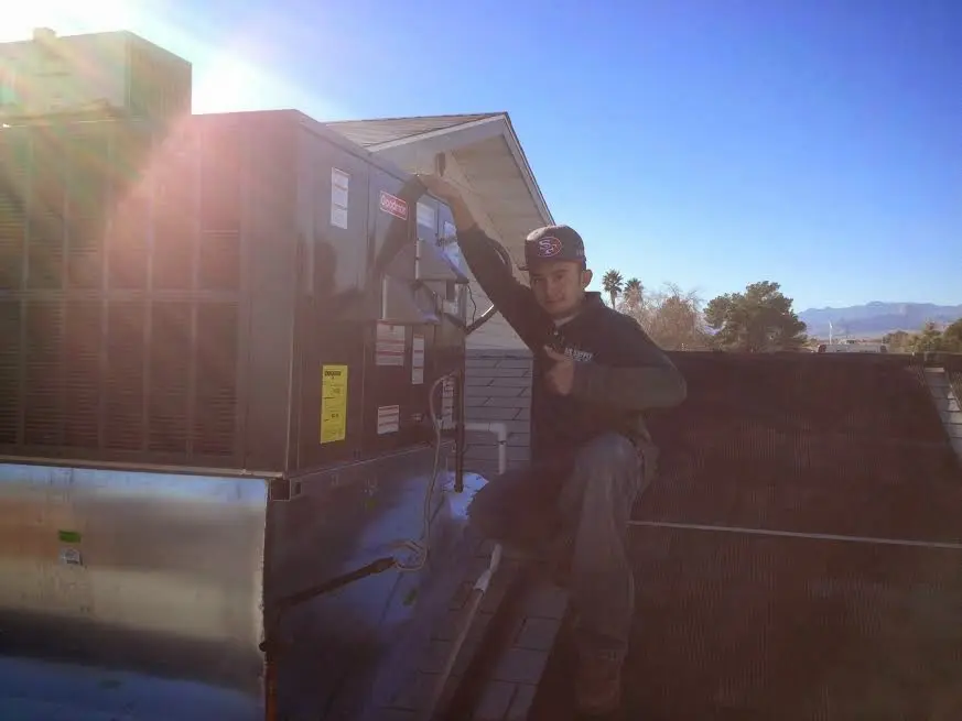 HVAC technician performing Heat Pump Repair on a rooftop unit in Ocoee